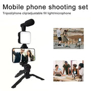 Smartphone vlogging kit with tripod, phone holder, mini microphone, and LED fill light for live streaming and video recording.