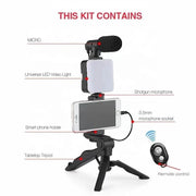 Smartphone vlogging kit with tripod, phone holder, LED fill light, shotgun microphone, and Bluetooth remote control for live streaming and video recording.