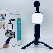 Smartphone vlogging kit with tripod, phone holder, mini microphone, and LED fill light for live streaming and video recording.