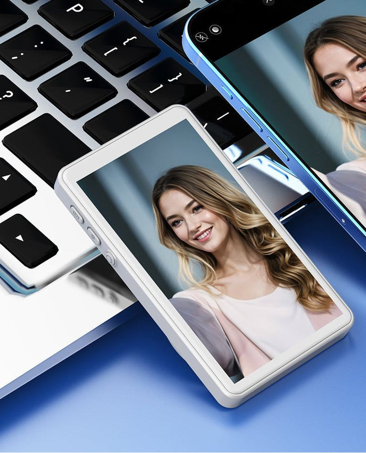 CamBuddyPro™ Magnetic Wireless Selfie Monitor white showing real-time rear camera preview of a smiling woman on phone screens near a laptop keyboard