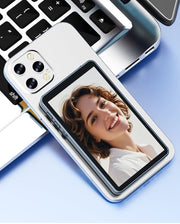 CamBuddyPro™ Magnetic Wireless Selfie Monitor showing real-time rear camera preview attached to a smartphone near a laptop keyboard